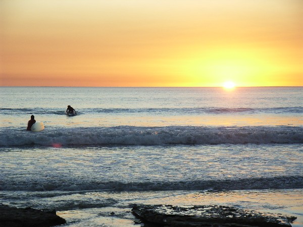 Surfers in the Indian Ocean at sunset - Cable Beach, Broome, Australia