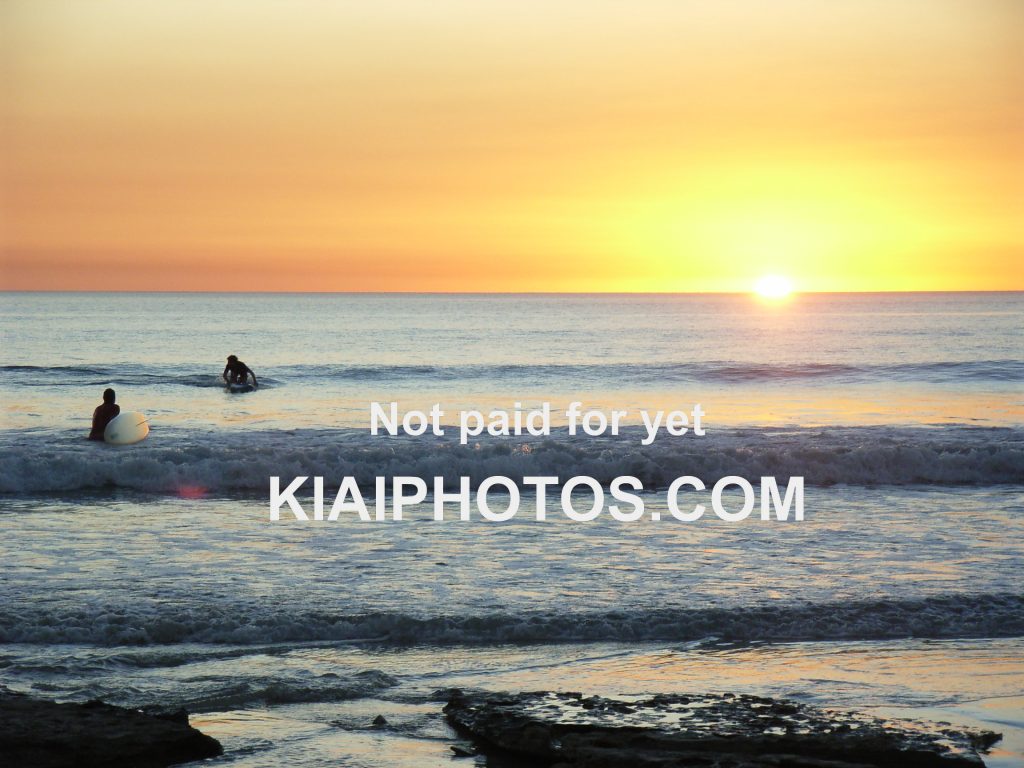 Surfers in the Indian Ocean at sunset - Cable Beach, Broome, Australia